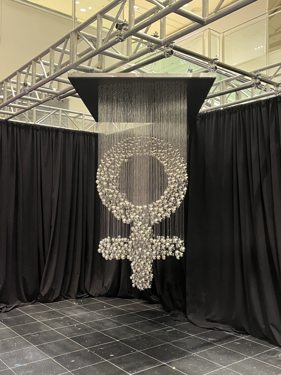 The same silver elements align to form the female symbol from another angle