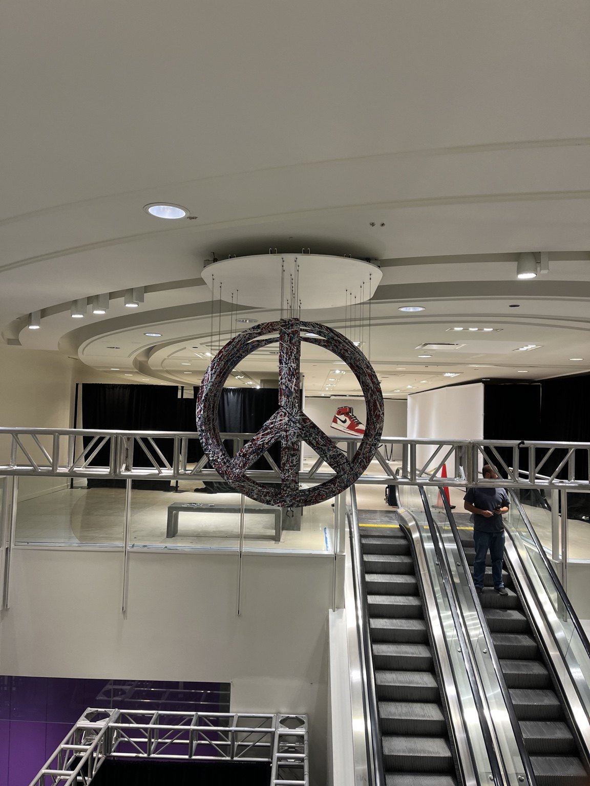 The same suspended artwork aligns to form a peace sign