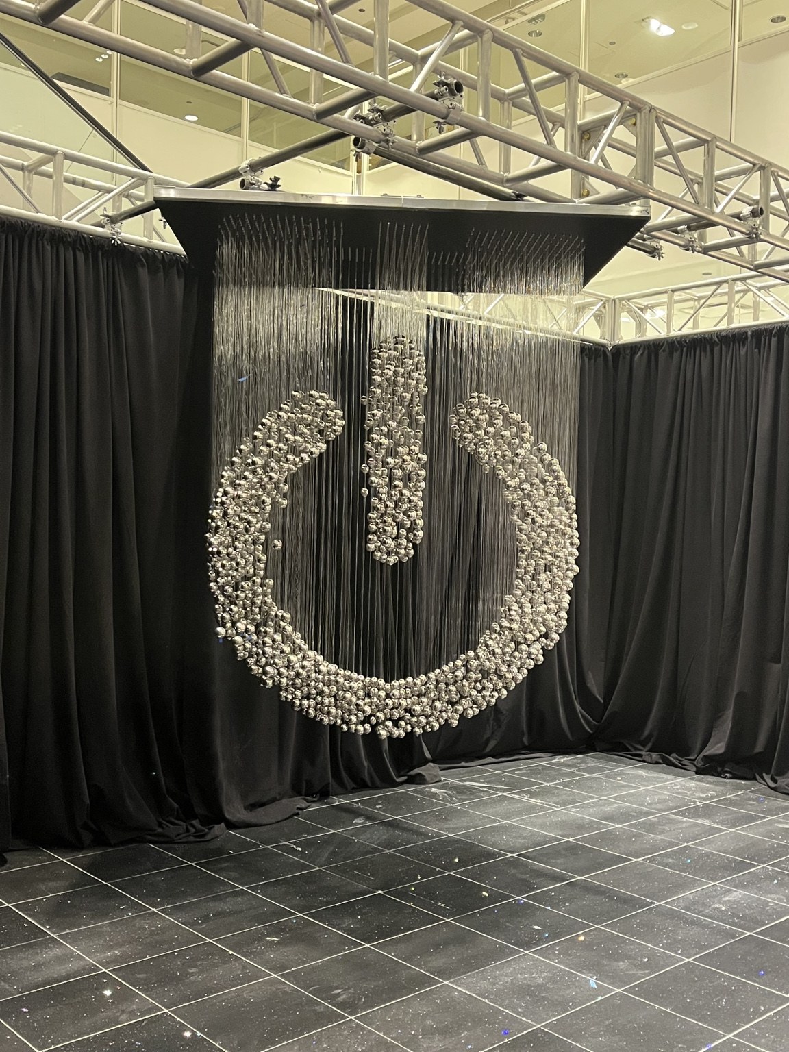 Suspended silver elements align to form a power button symbol