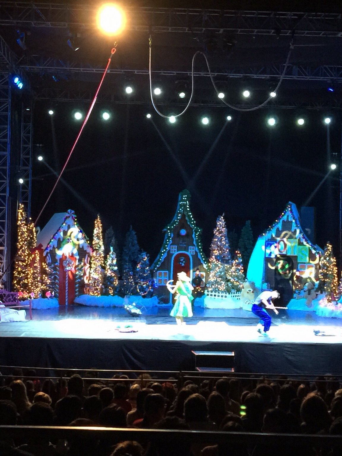 Santa Circus performance with Christmas scenery, illuminated trees and overhead rigging